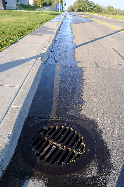 istock Water Pouring into Street Storm Drain 120499686
