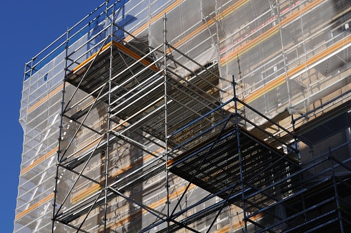 Scaffolding and safety netting on apartment building during renovation.