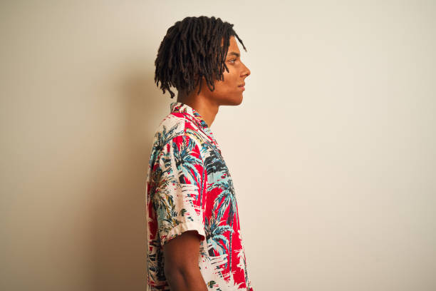 istock Afro man with dreadlocks on vacation wearing summer shirt over isolated white background looking to side, relax profile pose with natural face with confident smile. 1205001792