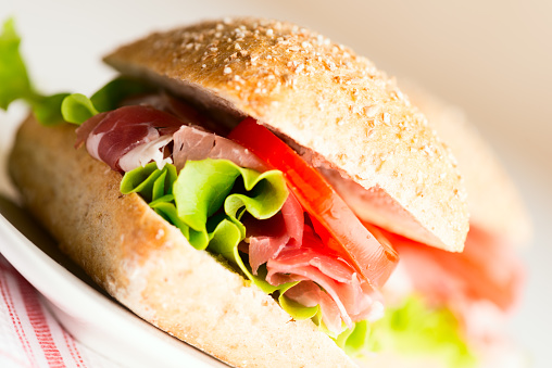 Prosciutto sandwich on plate close up. Selective focus, shallow DOF