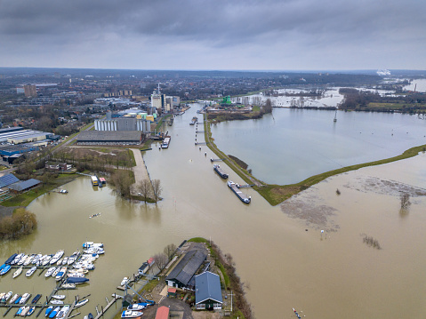 Flooded river landscape with submerged floodplains along river Rhine in winter period near harbor of Wageningen, the Netherlands