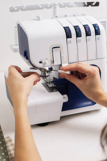 istock Women at work: Girl threading the needle of a sewing machine. 1205004288