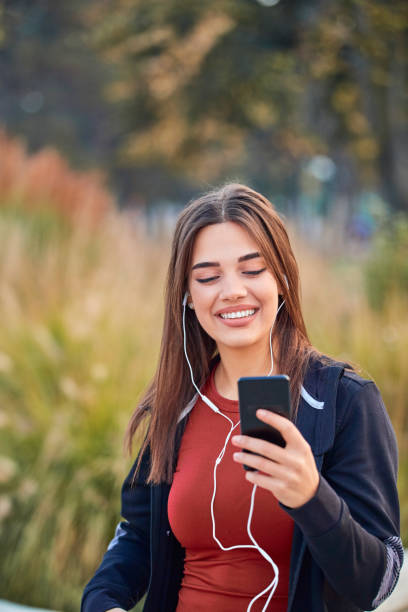 istock Modern young woman with cellphone making pause during jogging / exercise. 1205005489