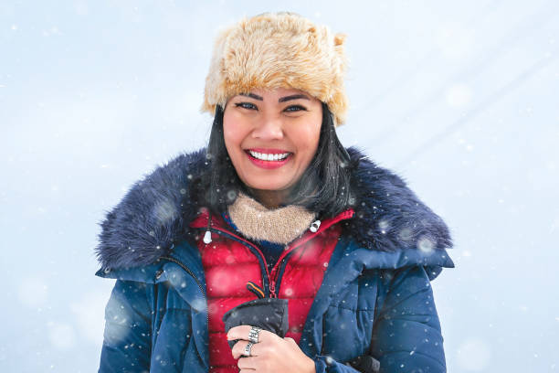 Asian woman enjoying with snow in winter break stock photo