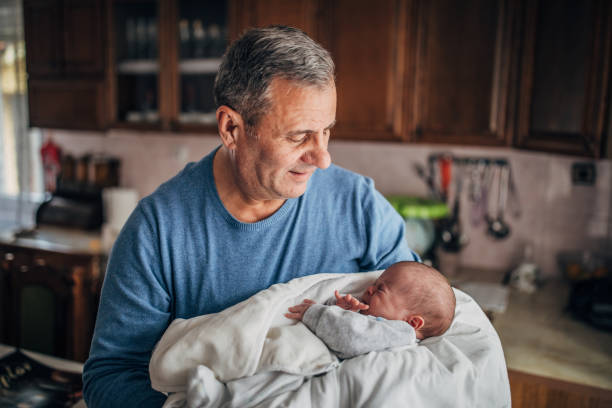 Grandfather is holding baby grandson.
