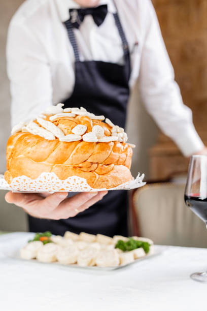 istock Waiter bringing orthodox homemade bread at the table. 1205010000