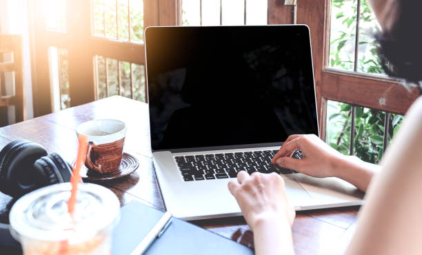 istock Cropped shot of young female using laptop while sitting in cafe. 1205010442