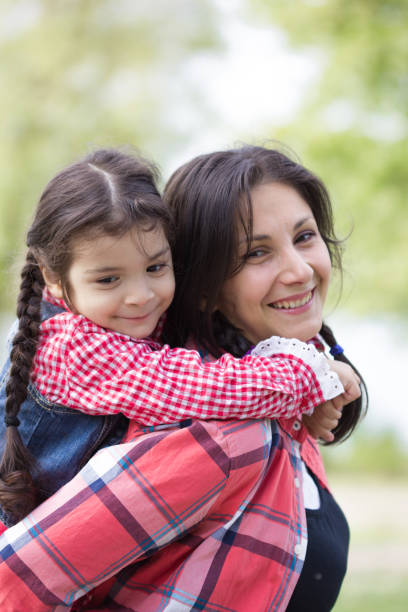Mother and daughter having fun in the park. Happy family concept. Beauty nature scene with family outdoor lifestyle. Happy family resting together. Happiness and harmony in family life. Mother's Day madre e hija divirtiéndose en el parque. concepto familiar feliz. escena de la naturaleza de la belleza con estilo de vida al aire libre de la familia. feliz familia descansando juntos. felicidad y armonía en la vida familiar. día de la madre