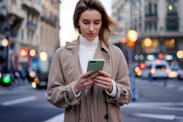 istock Young woman with smartphone on night street 1205011122
