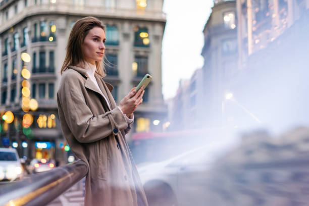 istock Young woman with smartphone on night street 1205011271