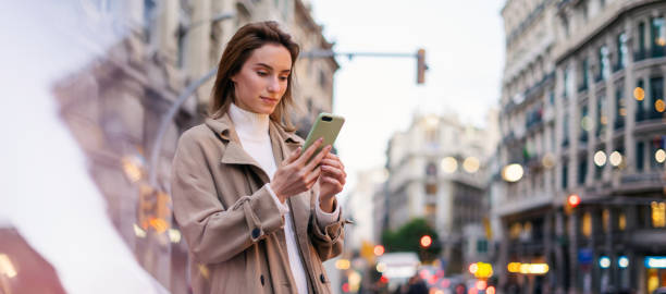 istock Young woman with smartphone on night street 1205011283