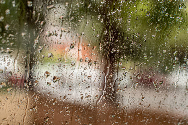 Heavy torrential rain on the street through the window with raindrops Heavy torrential rain on the street through the window with raindrops queensland floods stock pictures, royalty-free photos & images