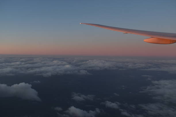 항공기 날개 아래 극적인 일몰 빛과 하늘에 아름다운 구름, 비행기 창에서 보기. - skeg 뉴스 사진 이미지
