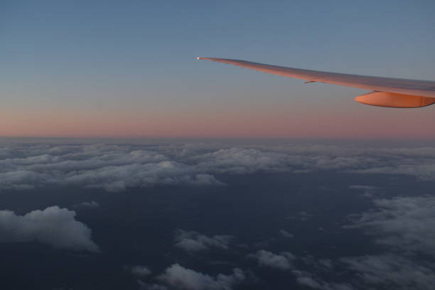 beautiful clouds on the sky with dramatic sunset light under aircraft wing, view from airplane window. - skeg imagens e fotografias de stock