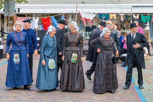 Urk, The Netherlands - September 07, 2019: Dance group with traditional clothing and headgear at a local fair with old costumes in Dutch fishing village Urk