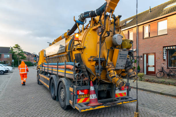 trabalhadores com sistema especializado de limpeza de caminhões em área residencial - sewage truck - fotografias e filmes do acervo