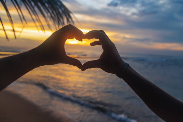 istock A girl and a man make hands a heart at sunset. Sri Lanka. Selective focus. 1205013255