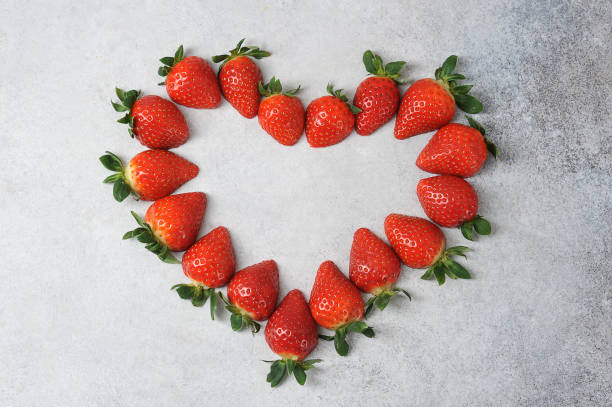 istock Strawberries on the table surface form a heart shape. View from above. 1205014116