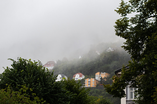 Hillside homes at Floyfjellet on a rainy and partly foggy autumn day in Bergen Norway