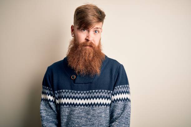 istock Handsome Irish redhead man with beard wearing winter sweater over isolated background skeptic and nervous, frowning upset because of problem. Negative person. 1205015897