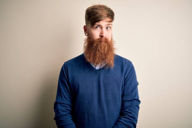 istock Handsome Irish redhead business man with beard standing over isolated background skeptic and nervous, frowning upset because of problem. Negative person. 1205015991