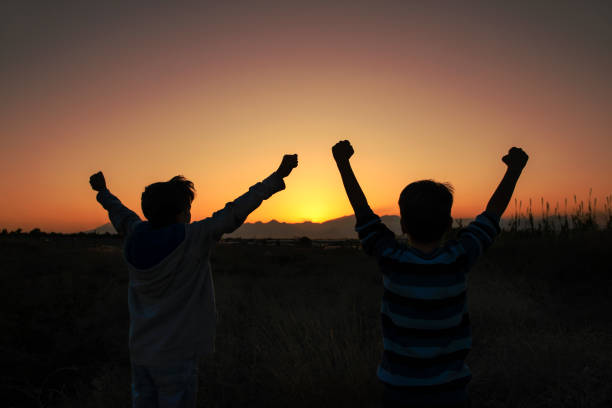 시골에서 일몰을 응원하는 두 행복한 친구의 샷 - cheering men shouting silhouette 뉴스 사진 이미지