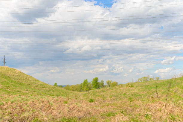 istock Landscape with grass in a ravine and power lines against the sky 1205018948