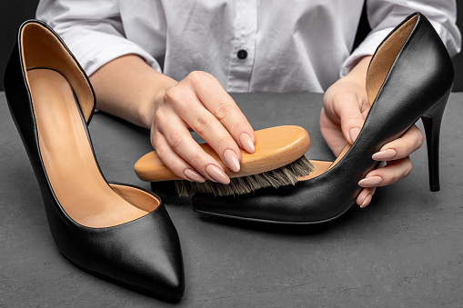 Leather shoes care concept. Shoe cleaning and polishing background with free copy space. Pair of leather shoes with high heels close up.