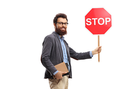 Bearded man holding books and a traffic stop sign isolated on white background