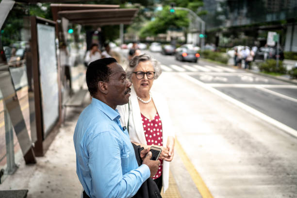 Coworkers talking at bus stop at city