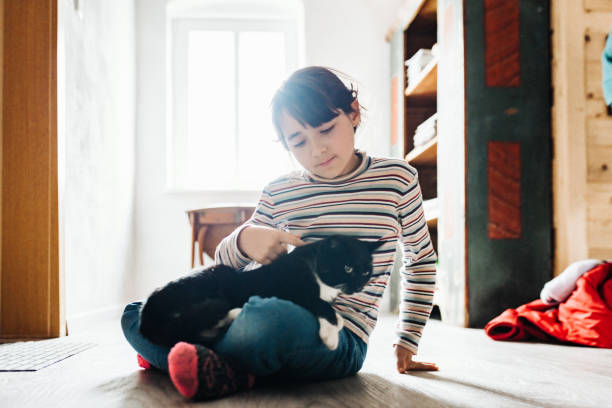 istock little girl stroking black cat 1205029952