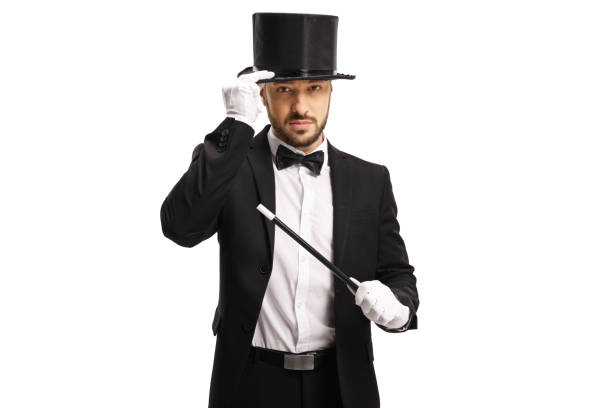 istock Magician with a magic wand holding his hat and looking at camera 1205030204