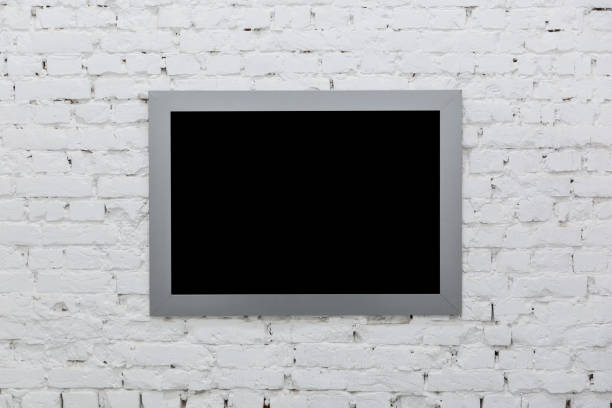 istock Empty frame from a painting on a white brick wall. Black place mock up 1205030421