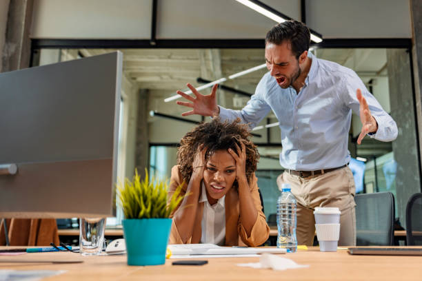 Next time you mess up, you're out! Male and female Office employees having argument at workplace. evil stock pictures, royalty-free photos & images