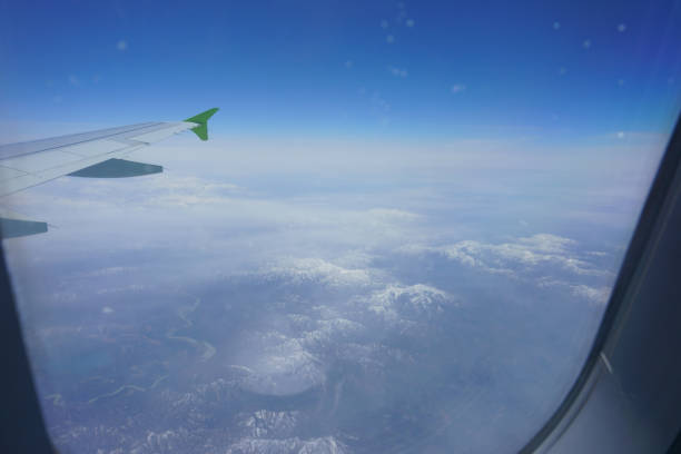 istock Airplane view of mountains with snow and wing 1205036571
