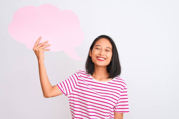 istock Young chinese woman holding cloud speech bubble standing over isolated white background with a happy face standing and smiling with a confident smile showing teeth 1205039028