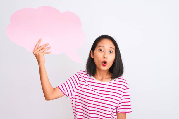 istock Young chinese woman holding cloud speech bubble standing over isolated white background scared in shock with a surprise face, afraid and excited with fear expression 1205039030