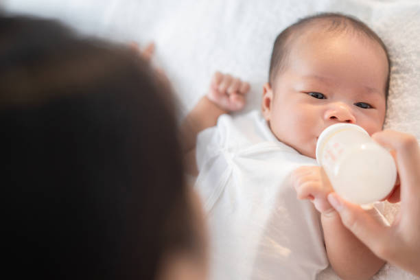 istock Mother feeds baby bottles 1205039862