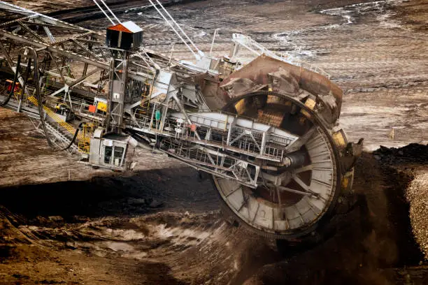 Large bucket wheel excavator mining machine at work in a brown coal open pit mine.