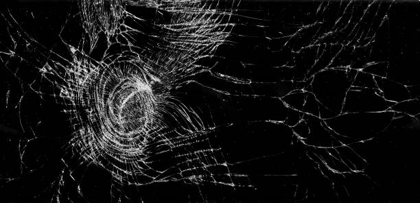 istock White cracks on black background. Cracked glass closeup. 1205042095