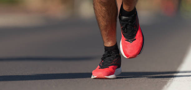 istock Fast strong runner feet running on asphalt road 1205042497