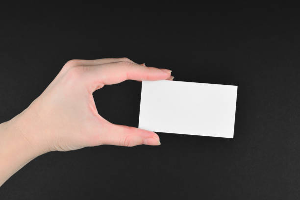 istock Empty card in woman hand  on a black background. 1205042538
