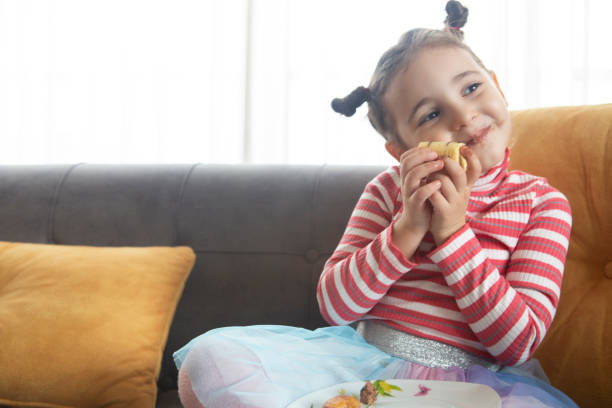istock Little girl eating cake 1205042556