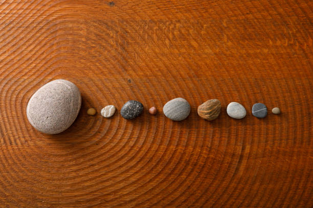 Pebble stones arranged on a wooden floor to a circular orbit
