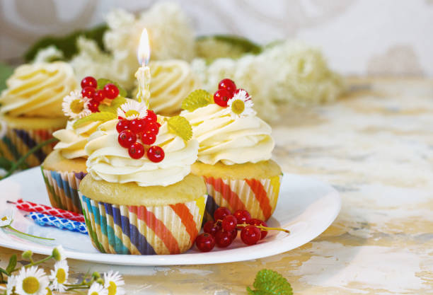 istock Gentle, festive cupcake with cream and berries nd a candle a light background 1205058626