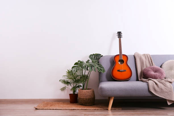 mniejsza gitara z mahoniową szyją i gładką podstrunnicy z drzewa różanego - apartment domestic room living room wall zdjęcia i obrazy z banku zdjęć