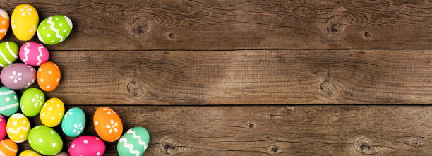 striscione pasquale colorato con bordo ad angolo delle uova di pasqua su uno sfondo in legno scuro con spazio di copia - wood eggs easter easter egg foto e immagini stock