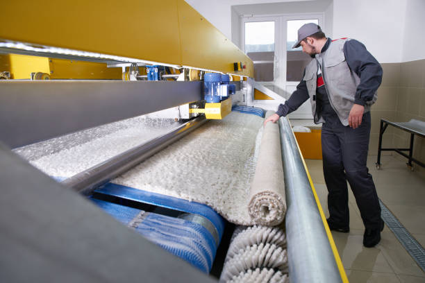 istock Laundry worker in the process of working on automatic machine for carpet washing in dry cleaning 1205064324