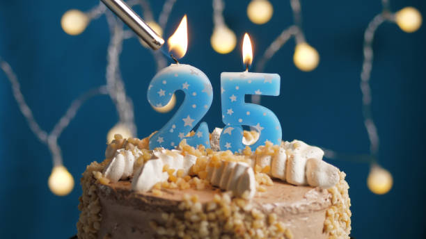Birthday cake with 25 number candle on blue backgraund set on fire by lighter. Close-up Birthday cake with 25 number candle on blue backgraund set on fire by lighter. Close-up view number 25 stock pictures, royalty-free photos & images