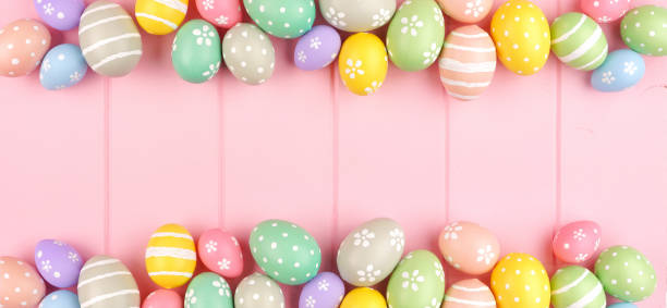 istock Easter banner with double border of pastel Easter Eggs over a pink wood background with copy space 1205067002